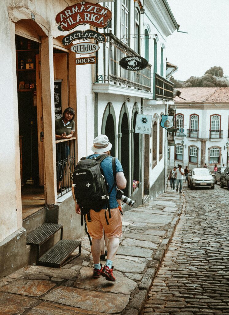 A solo traveler with a backpack walks down a cobblestone street with historic architecture in view. SEO Travel Case Study