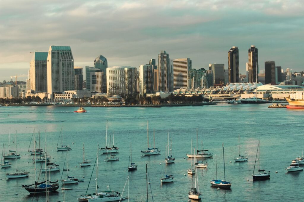 pexels-photo-34271111-34271111 A picturesque view of the San Diego skyline with sailboats anchored in the harbor under a cloudy sky.