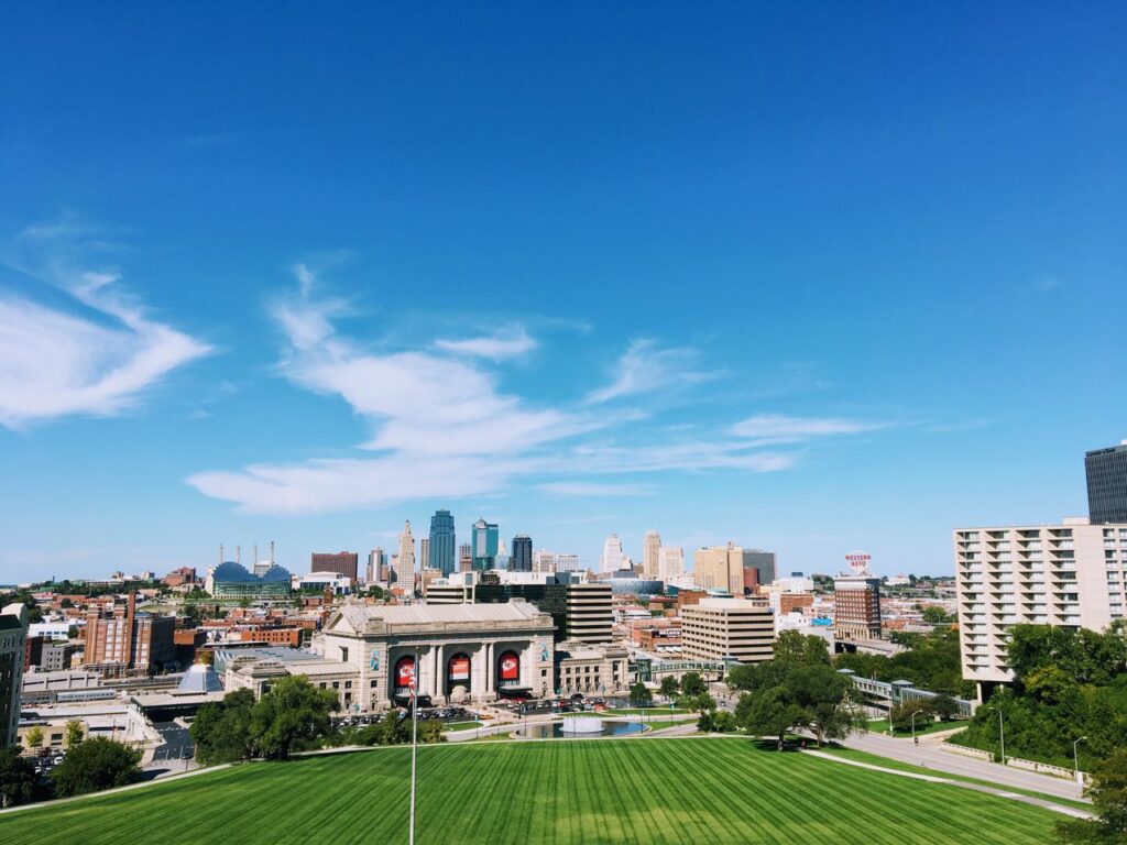 pexels-photo-349506-349506 Wide-angle shot of Kansas City's skyline with clear blue skies and vibrant green foreground.